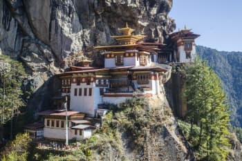 Stunning view of Tiger's Nest Monastery perched on a cliff in Bhutan's mountains.